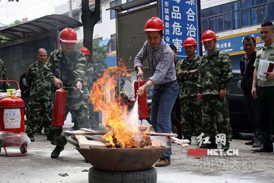 (湖南省漣源市消防大隊聶指導員在指導橋頭河鎮消防隊隊員使用滅火器滅火。)