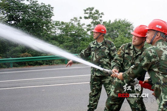 (2015年5月13日,湖南省漣源市橋頭河鎮消防隊隊員們在進行消防訓練。