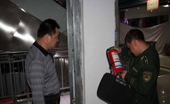 消防監督員在商場檢查滅火器材